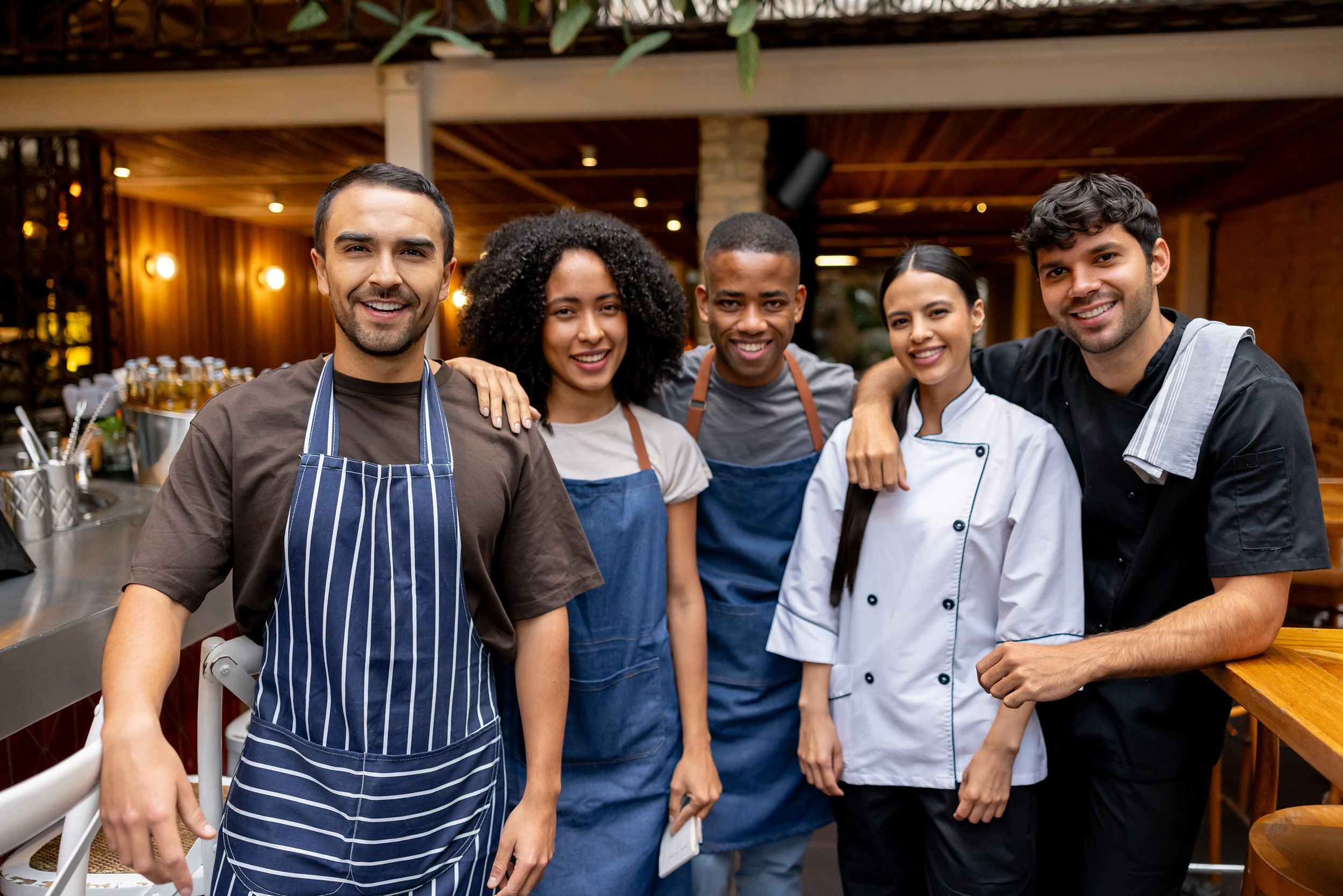 Five restaurant workers smiling at the camera