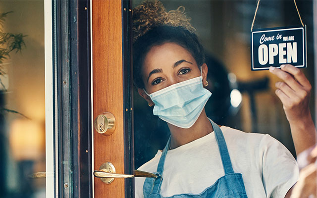 Woman with OPEN sign wearing mask - Reopening & Recovery