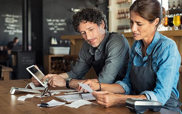 Two people reviewing receipts at table - Restaurant Preparedness