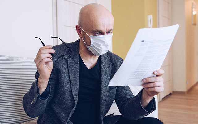 Man with glasses and statistics paper in hand - National Restaurant Association Research Reports