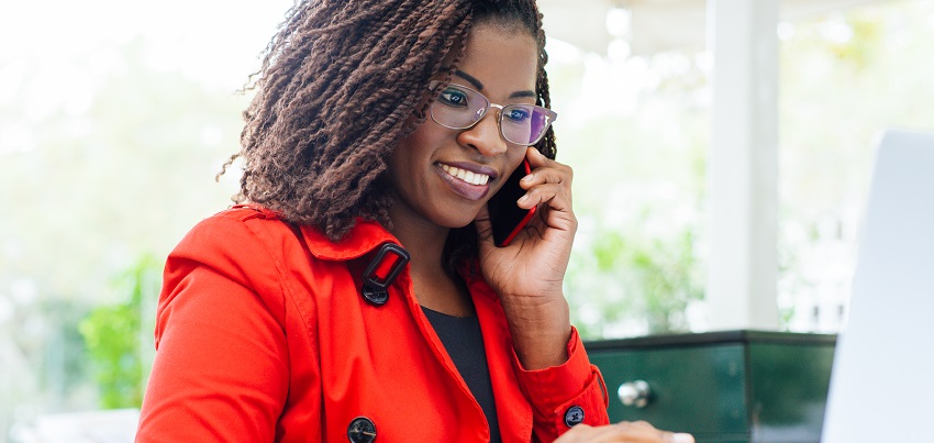 Woman using a phone and laptop