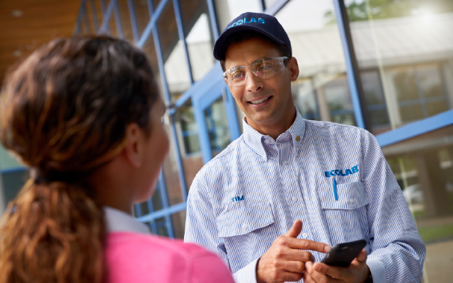 Photo of a male Ecolab technician speaking with a woman