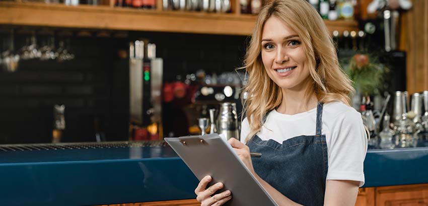 Waitress holding a clipboard wearing blue apron