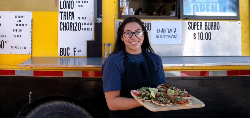 Woman holding a plate with tacos