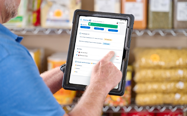 photo of a man in a storeroom using an ipad
